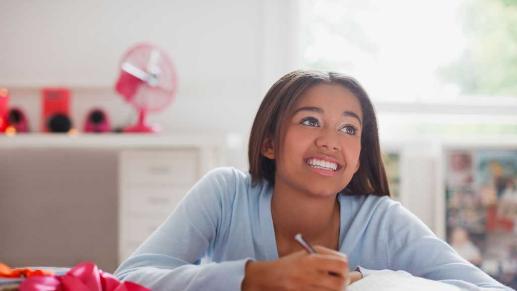 teenager writing and looking up