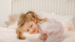 little girl in pajamas bending over in pain